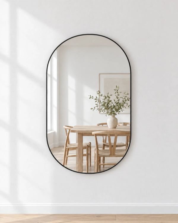 Elva ovale wandspiegel 80x50 cm met zwart metalen frame in een lichte eetkamer